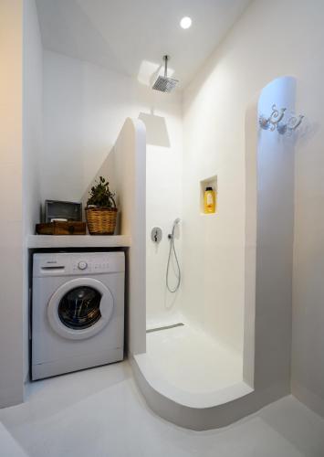 a white laundry room with a washer and dryer at The Aegean blue country house Old Milos in Lagoúdi Zía
