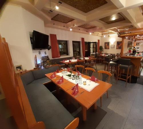 a dining room with a table and a couch at Hotel Lindenhof in Rödermark