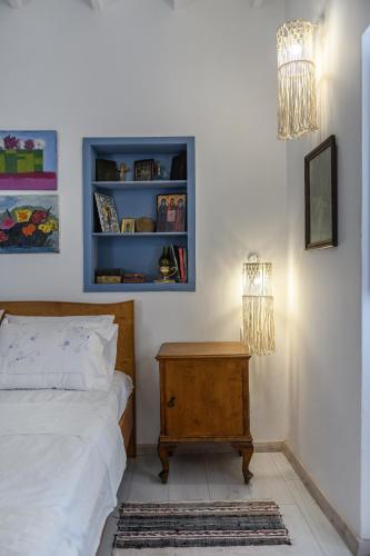 a bedroom with a bed and a nightstand and a lamp at The Aegean blue country house Old Milos in Lagoúdi Zía