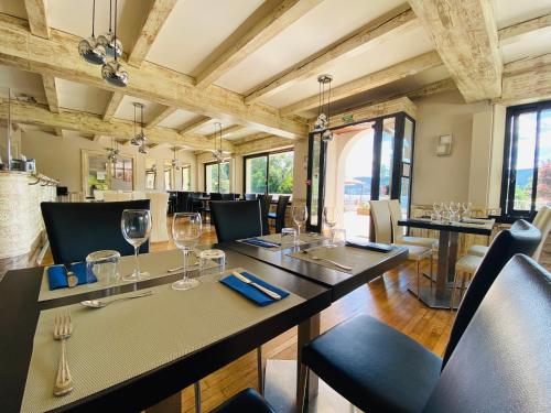 a dining room with tables and chairs and windows at Le Chalet au bord du lac in Gérardmer