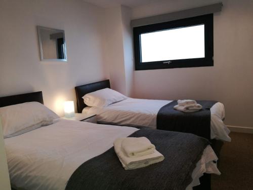 格拉斯哥的住宿－Glasgow Central Riverview Luxury Apartment (Sleeps upto 8)，酒店客房设有两张床和窗户。