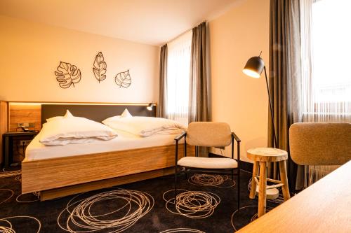 Habitación de hotel con cama, mesa y sillas en Hotel Rio en Karlsruhe