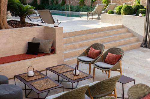 a patio with chairs and tables and stairs at Can Aulí Luxury Retreat - Adults Only in Pollença
