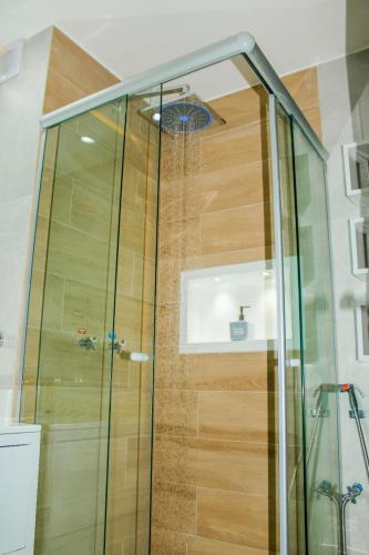 a shower with a glass door in a bathroom at Ponta Negra Beach Flat Prime in Natal