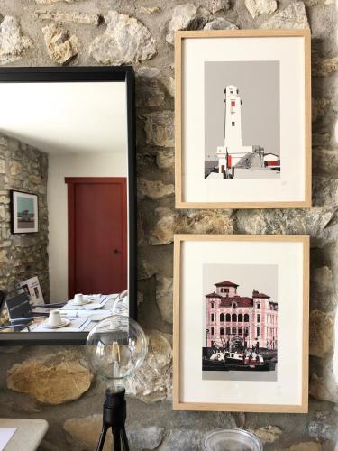 ein Satz von drei Bildern an einer Steinmauer mit einem Leuchtturm in der Unterkunft La ferme d'Ika in Saint-Jean-de-Luz