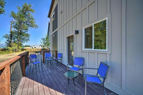 a deck with blue chairs and a table and a window at Bozeman Home with Deck Walk to Fishing, Hot Springs in Bozeman