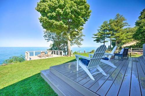 a wooden deck with two chairs and a table at Modern Lake Michigan Home with 3 Lakefront Decks! in Holland
