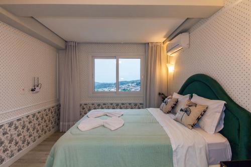 a bedroom with a large bed with a window at Residencial Via Florida Gramado in Gramado