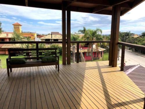 a wooden porch with a bench on a deck at Pitaya Apart Hotel in Garopaba