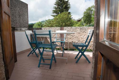 - deux chaises bleues et une table sur une terrasse dans l'établissement Appartamento Le Betulle, à Erbezzo