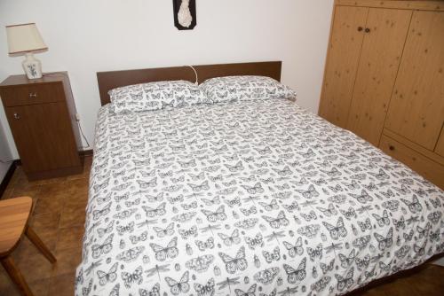- un lit avec une couette et des oreillers en noir et blanc dans l'établissement Appartamento Le Betulle, à Erbezzo