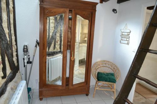 a wooden cabinet in a room with a chair at Le Pigeonnier, maison de charme au pied du château in Amboise