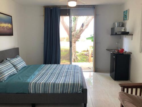 Schlafzimmer mit einem Bett und einer Glasschiebetür in der Unterkunft Las Olas Beach apartments in Arecibo