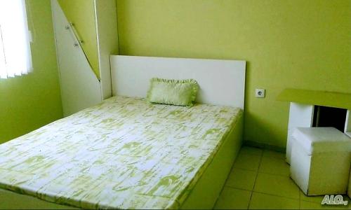 a green room with a bed with a pillow on it at АПАРТАМЕНТ LEO 4 in Varna City