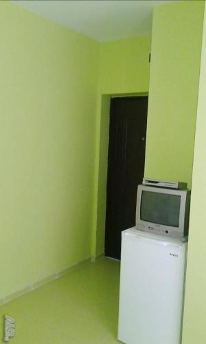a microwave on top of a refrigerator in a room at АПАРТАМЕНТ LEO 4 in Varna City