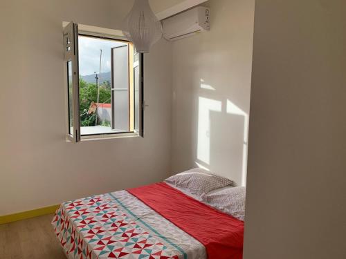 a bedroom with a bed with a window at Cyparis in Saint-Pierre