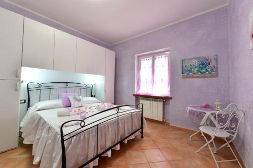 een slaapkamer met paarse muren en een bed en een tafel bij B&B Roman Country Villa in Zagarolo