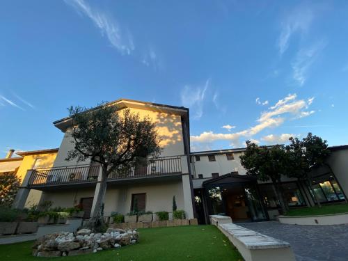 ein Gebäude mit einem Baum davor in der Unterkunft Le Grazie Hotel in Assisi