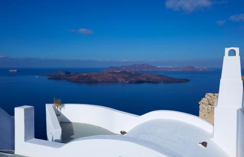 a view of the ocean from the side of a white building at Volcano View by Caldera Collection in Fira
