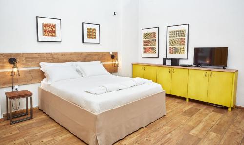 - une chambre avec un grand lit et une télévision dans l'établissement Aris Athens Suites, à Athènes