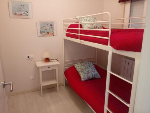 a bedroom with two bunk beds with a red mattress at Casa Marinera in Baiona