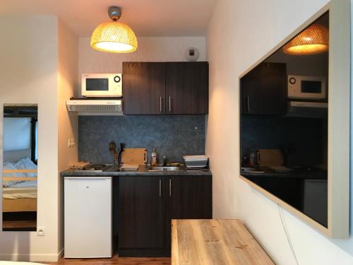 une cuisine avec des armoires marron et un comptoir dans l'établissement Studio à 150m RER Val d’Europe. Disney/Paris, à Montévrain