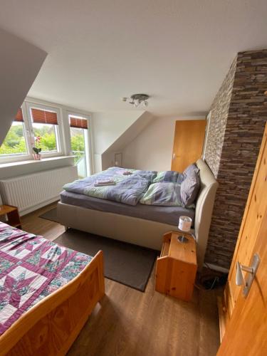 a bedroom with a bed and a brick wall at Haus Dres Ferienwohnung 1 und 2 in Aventoft