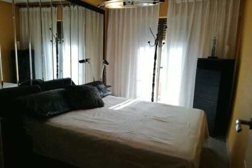 a bed in a room with a large window at Casa con terraza/Confortable house with terrace in Aigues