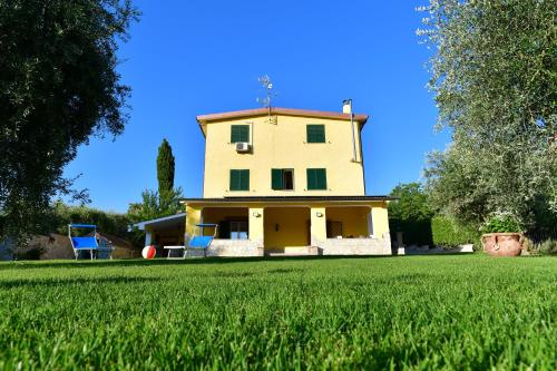 a yellow house with a yard with a grass field at B&B Roman Country Villa in Zagarolo
