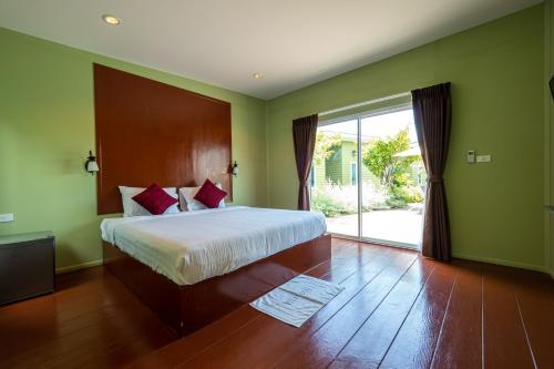 a bedroom with a bed and a sliding glass door at Sky Hip Resort - SHA Certified in Jomtien Beach