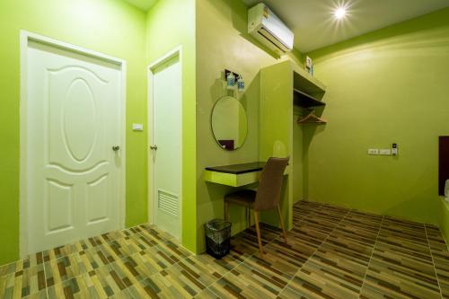 a room with a desk and a mirror and a door at Sky Hip Resort - SHA Certified in Jomtien Beach