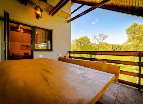 una gran mesa de madera en una habitación con una gran ventana en Casa Nitu, en Întorsura Buzăului