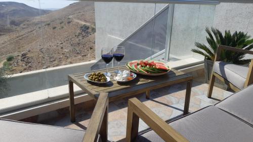 una mesa con un bol de fruta y dos copas de vino en " ARADA " Luxury House en Arad