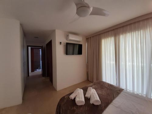 ein Schlafzimmer mit zwei weißen Handtüchern auf einem Bett in der Unterkunft Taibá Beach Resort casa térrea ou chalet enteiro in Taíba