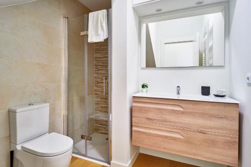 een badkamer met een toilet, een wastafel en een spiegel bij VUT San Cristóbal LARANITASALAMANTINA in Salamanca