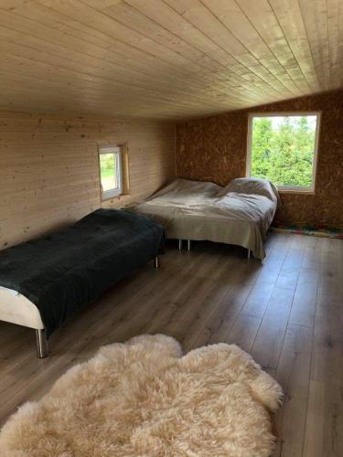 a bedroom with two beds in a wooden cabin at Pas Garfildą in Vatušiai