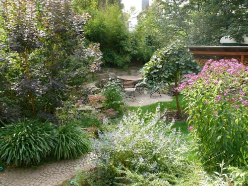 Villa Am Park في إرفورت: حديقة فيها كرسي وسط الزهور