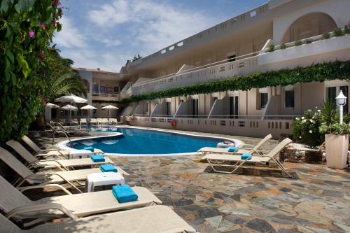 a hotel with lounge chairs and a swimming pool at Axos in Platanes