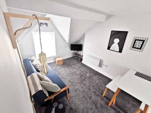 een woonkamer met een blauwe stoel en een bureau bij Richmond Apartments by Switchback Stays in Cardiff