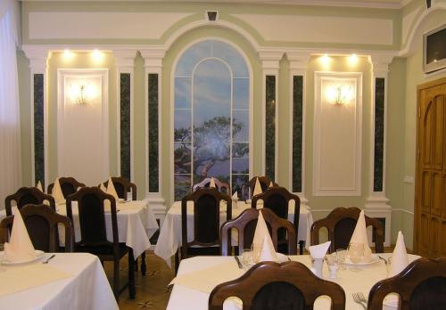 a conference room with tables and chairs and a window at Dnipro Hotel in Cherkasy