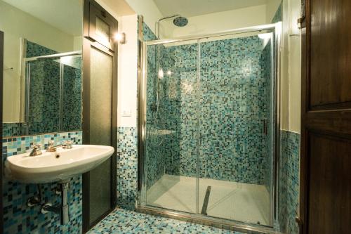 a bathroom with a glass shower and a sink at Casa Silvana in Alba