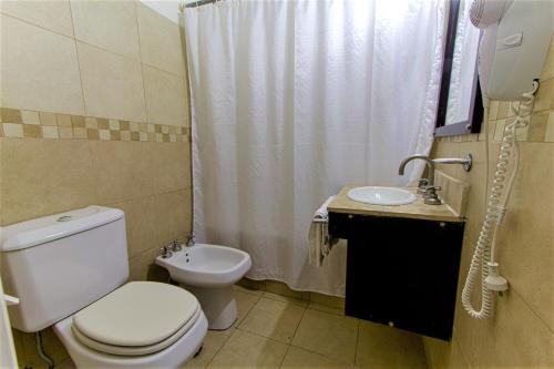 a bathroom with a toilet and a sink at Hotel Libertador de Pinamar in Pinamar