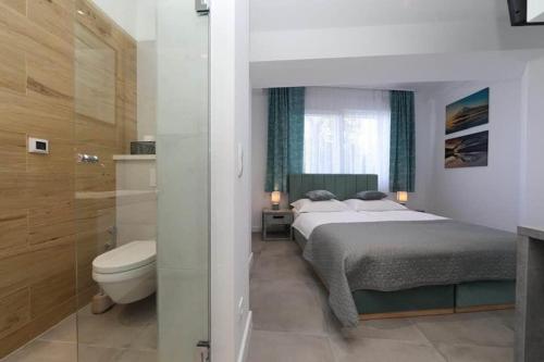 a bedroom with a bed and a bathroom with a toilet at Apartment Anastazija in Omiš