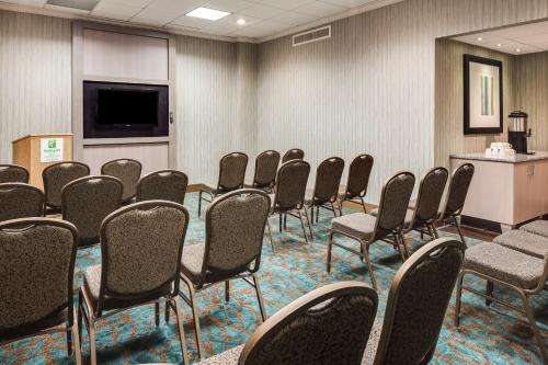 a conference room with chairs and a flat screen tv at Holiday Inn Rock Island-Quad Cities by IHG in Rock Island