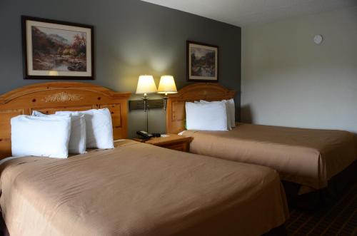 Habitación de hotel con 2 camas y 2 lámparas en Clarksville Inn, en Clarksville