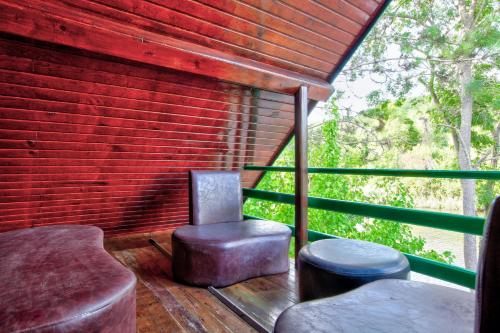 a porch with a chair and a stool and a brick wall at Paradise Plus Ağva in Agva