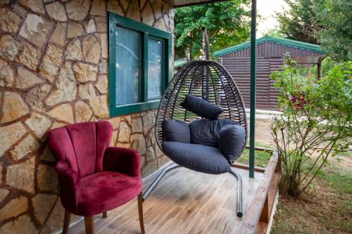 a swing and two chairs sitting on a deck at Paradise Plus Ağva in Agva