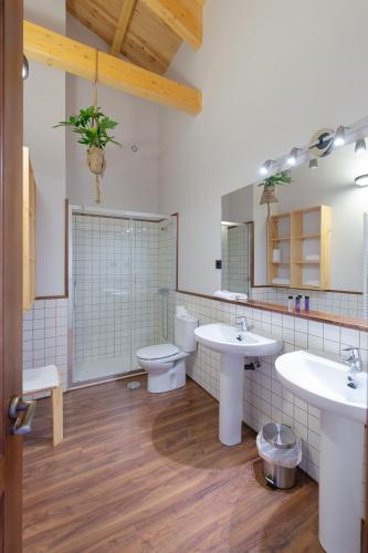 a bathroom with two sinks and a toilet at La Rosaleda León - Casa Rural - in Hospital de Órbigo
