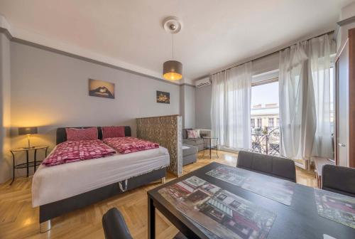 ブダペストにあるAstoria Balcony Apartmentのベッドルーム1室(ベッド1台、テーブル付)、ダイニングルームが備わります。