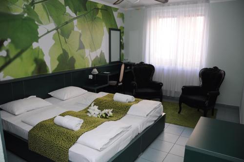 ein Schlafzimmer mit einem großen Bett mit zwei weißen Kissen in der Unterkunft Green Hotel Budapest in Budapest